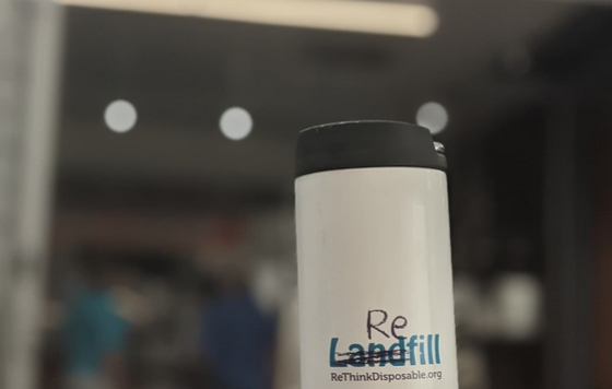 Reusable coffee mug with scribble over the word "Landfill" to read "Refill". Rethinkdisposable.org